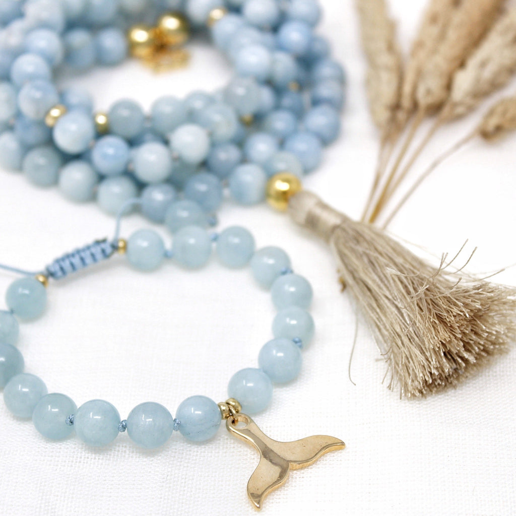 Yemaya bracelet  hand-knotted with 8mm Grace A Aquamarine beads and strung with a gold plated Whale/Mermaid tail pendant. 