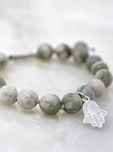 Serenity bracelet hand-knotted with 8mm faceted Peace jade beads and a sterling silver Hamsa pendant.   
