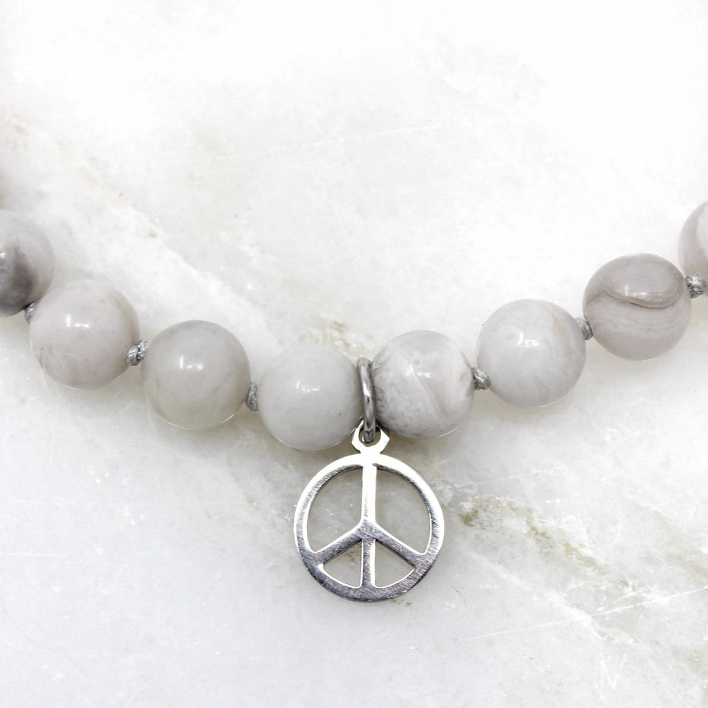 Tara Bracelet hand-knotted with 8mm crazy laced agate beads and stainless steel Peace pendant.